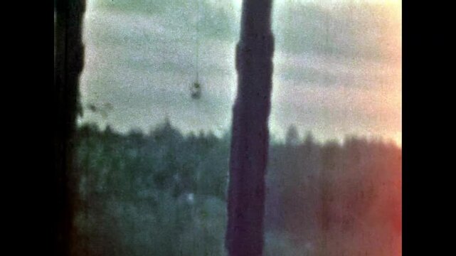 Old rural window view in green forest. Lonely, quiet lifestyle inside village house. No people. Country home surrounded by summer nature. Vintage color film. Family archive. Retro 1960s countryside