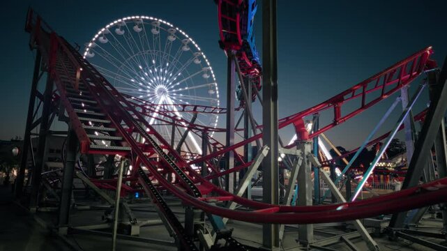  illuminated amusement park. Neon carousel ferris wheel and roller coaster slow motion. Summer holidays and fun for children