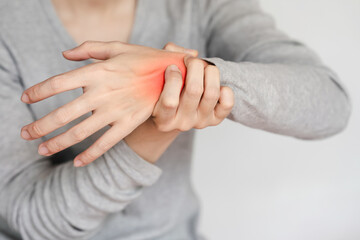 Close-up of a person's hand experiencing wrist pain and discomfort, highlighted by a red mark, showcasing a health issue or injury.