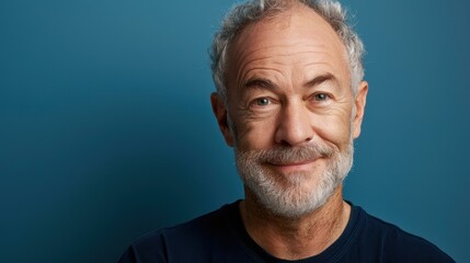 Portrait of a midaged man looking confidently at the camera in a studio setting.