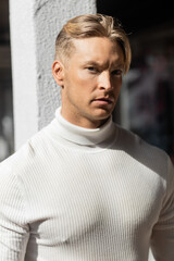 portrait of handsome man in white turtleneck looking at camera