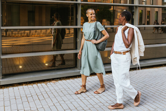 Confident businesswomen walking and talking outdoors