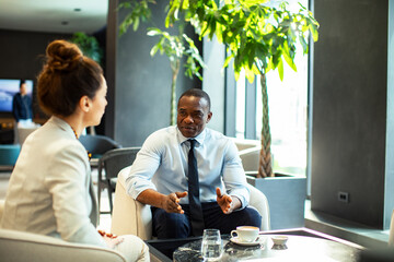 Diverse business people having meeting in hotel restaurant