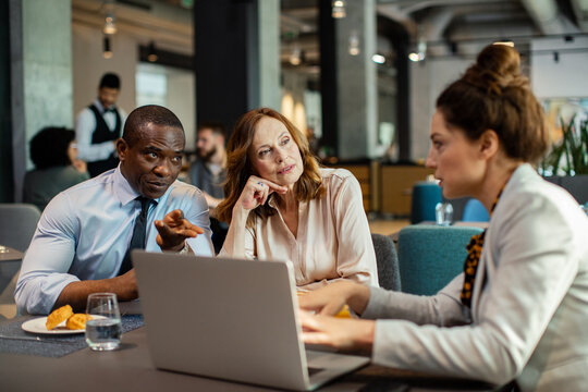 Diverse business people having meeting in hotel restaurant