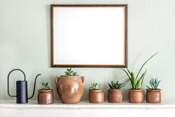 Mock up photo frame and variety of succulent home plants on a white shelf
