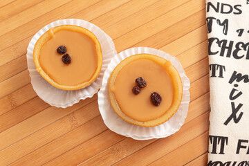 Two delicious Colombian desserts filled with arequipe on a wooden table next to a cloth napkin. Dulce de leche with raisins. Typical sweet food.