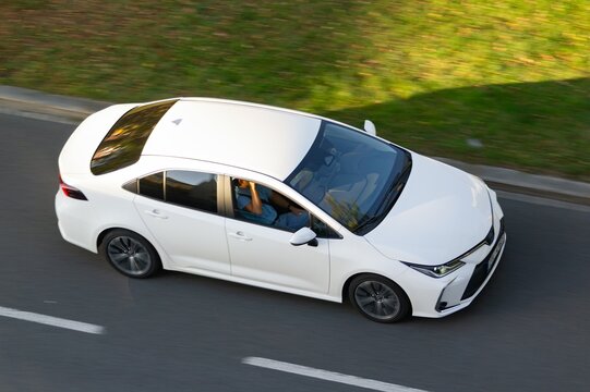 White Toyota Corolla E210 Sedan car driving quickly, motion blur effect