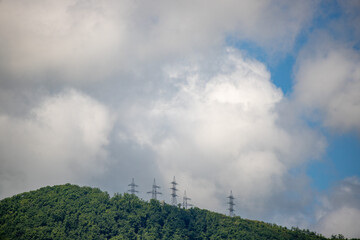 Nature, forested mountains, blue sky with white clouds.