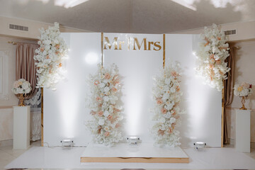 A white backdrop with a gold border and the words "Mr. And Mrs." written in gold