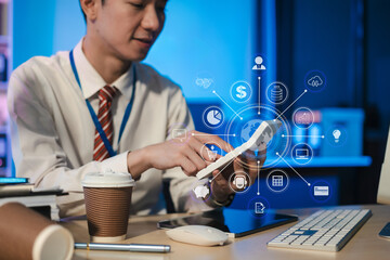 Business man using digital tablet analyzes business data, busy working on laptop computer with smart phone and business report on office desk, employees working overtime.