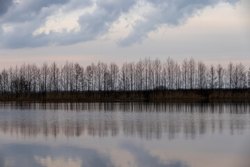 a beautiful reflection of the sky and clouds in the lake at sunset
