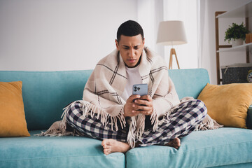 Photo of funky serious guy sleepwear pajama smiling relaxing home sofa chatting modern device...