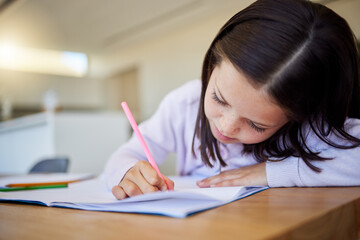 Child, writing and notebook for education at house with creative learning, drawing or motor skills development. Girl, paper and stationery for art sketch, assessment and homework activity in lounge