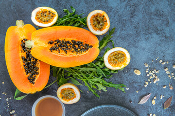 Papaya, passion fruit and rucola on a blue stone kitchen table background