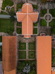 Old French Colonial Catholic Church from top down aerial view at Thu Thiem on bank of Saigon River, Ho Chi Minh City, Vietnam featuring architecture and symmetrical garden landscaping.