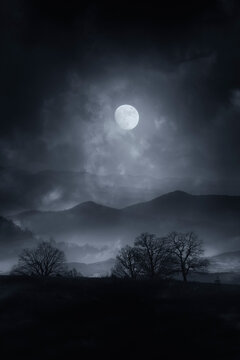 dark horror night landscape with full moon in the clouds