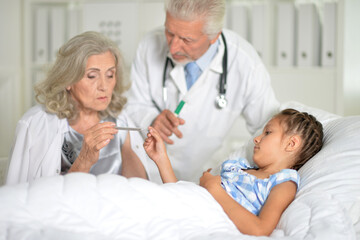 Obraz premium Little girl in the hospital with her grandmother and doctor
