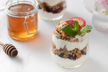 Yogurt with crispy granola, berries and honey for a delicious breakfast. Healthy eating.