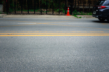 A car is driving down a street with a yellow line on the road. The street is empty and the car is the only thing visible