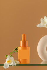 Enjoy the simplicity of a minimalist orange serum and floral vase displayed on a glass shelf. Skin care