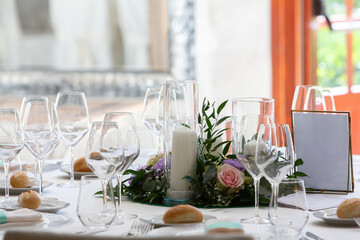 Round table decorated with candles and flowers for a wedding reception being held in a restaurant