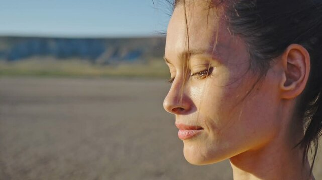Slow motion. Gorgeous young woman with a charming smile against the backdrop of a gentle magnificent summer sunset. Portrait