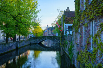 Obraz premium Old Town of Bruges, Belgium, famous landmark. Scenic cityscape with medieval historical buildings along the Groenerei canal at sunset, outdoor travel background