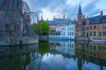 Most popular view of Old Town of Bruges from Rozenhoedkaai (Rosary quay), Belgium. Scenic cityscape with medieval historical buildings along the Dijver canal at sunset, outdoor travel background