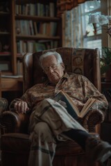 Obraz premium Senior man falling asleep while reading in comfortable armchair