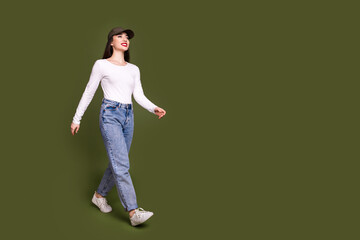 Full size photo of pretty young girl walking model cap wear trendy white outfit isolated on khaki color background