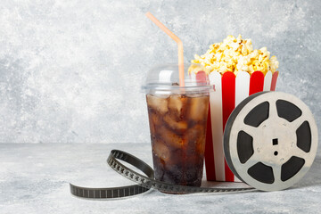 Tasty popcorn in buckets and cold cola drinks with cinema tickets, movie clapper and 3D eyeglasses...