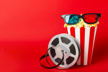 Tasty popcorn in buckets and cold cola drinks with cinema tickets, movie clapper and 3D eyeglasses...