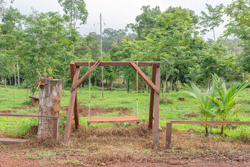 Old farm tractor in a field with a wooden fence and green landscape
