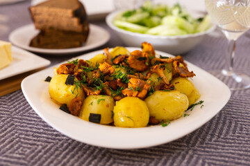 Rustic dish. fried potatoes with chanterelle mushrooms with herbs