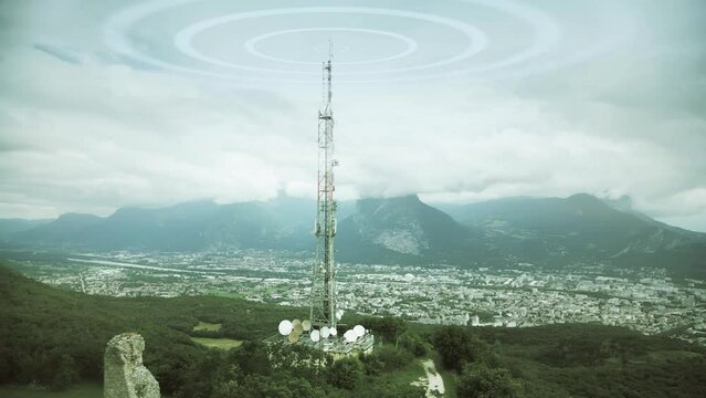 Aerial view of a 5G mobile network antenna emitting radio signals against urban background. Grenoble, French Alps, France. Electromagnetic wave visualization.