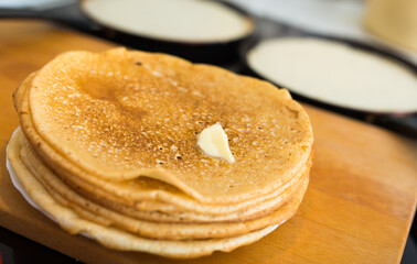Stack of appetizing flour pancakes in the kitchen during cooking