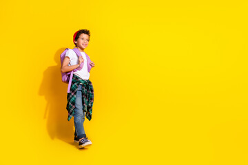 Full body photo of cute little boy backpack walk school dressed stylish white clothes isolated on yellow color background