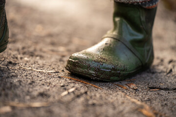 muddy boots of gumboots and wellies on a walk with mud and water in winter