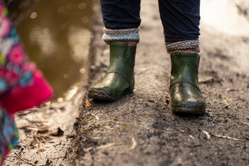muddy boots of gumboots and wellies on a walk with mud and water in winter