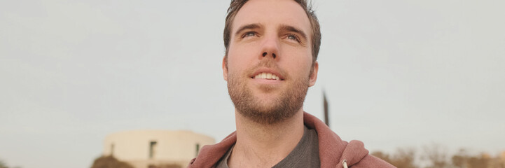 Obraz premium Young man enjoying walk on the beach, panorama