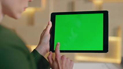 Girl finger swiping greenscreen tablet close up. Unknown woman surfing internet