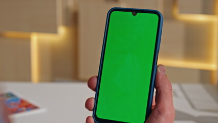 Employee scrolling chromakey mobile phone surfing internet in office close up.