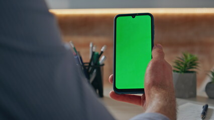 Closeup finger scrolling chromakey screen device at table. Man hand swiping cell