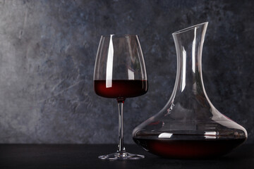 Red wine elegance: Decanter and wine glass against a stone background