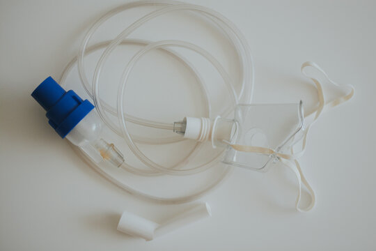 Inhalation apparatus consisting of a mask and tubes on a white background