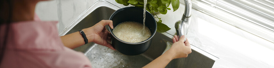 Header with housewife washing rice under water
