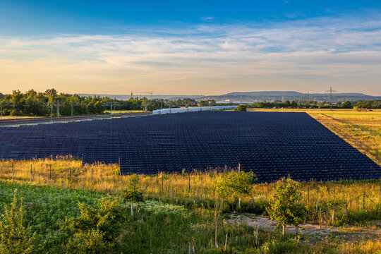 Ein gro&szlig;er weitl&auml;ufiger Solarpark in Bayern entlang einer Bahnstrecke.