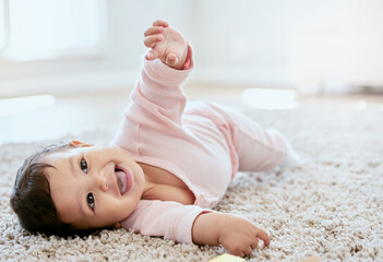 Happy, laughing and baby on floor in home for child development, wellness and growth. Family,...
