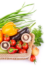 Fresh organic vegetables in the basket. Pepper, eggplant, tomatoes, mushrooms and greenery herbs with green leaves. Healthy natural food. Veggies, isolated on white background