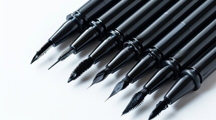 Naklejka premium A display of six black ink brush pens with diverse and unique tips, meticulously placed on a clean white backdrop, presenting an array of artistic possibilities and techniques.